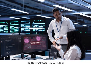 Programmers doing teamwork in server hub trying to protect hardware from hacker stealing information. Colleagues in data center workspace trying to fix security breach alert caused by virus