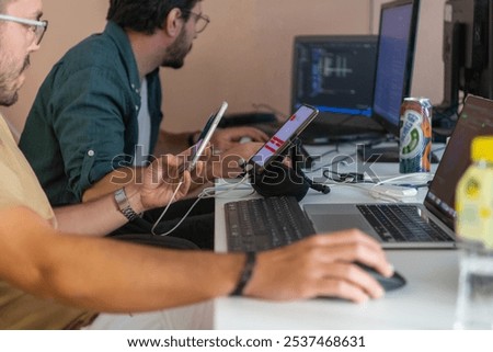 Programmers engrossed in deep collaboration, diligently working together to solve complex problems and develop innovative mobile applications with seamless functionality.
