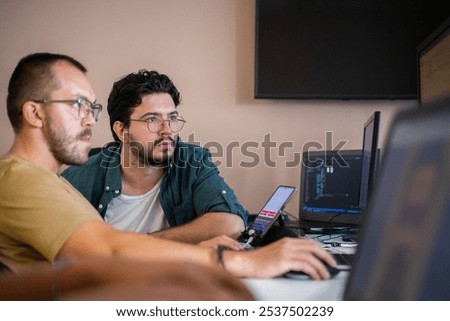 Programmers engrossed in deep collaboration, diligently working together to solve complex problems and develop innovative mobile applications with seamless functionality.