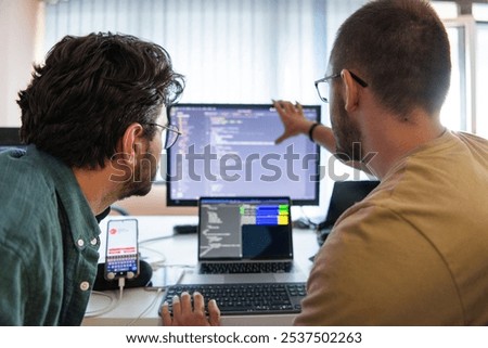 Programmers engrossed in deep collaboration, diligently working together to solve complex problems and develop innovative mobile applications with seamless functionality.