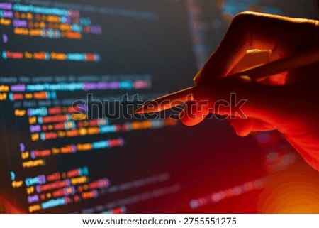The programmer's hands are writing computer code on a tablet.