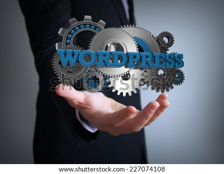 programming concept: text wordpress with gears over businessman hand