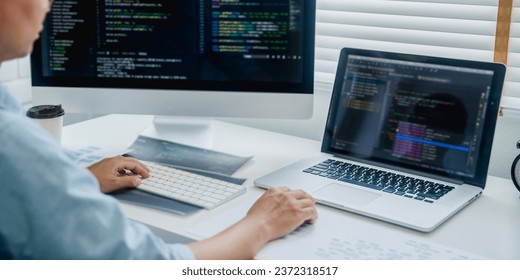 Programming developing software application. programmer writing program code with two monitors and working hacker on a new software.