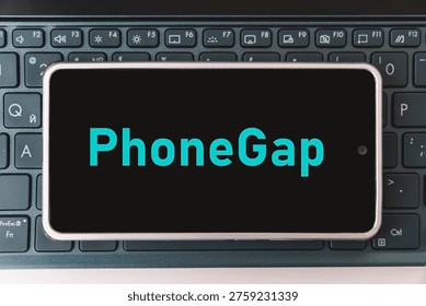 Programming for mobile development, concept. Smartphone on the laptop keyboard, the programmer workplace. inscription PhoneGap on the mobile phone screen , - Powered by Shutterstock - Get 15% off with code: PIKWIZARD15