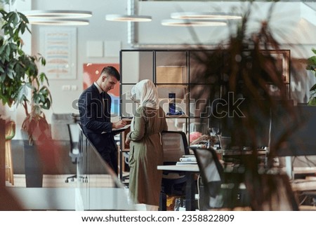 In the progressive setting of a modern startup office, the director engages in a discussion with a businesswoman wearing a hijab, illustrating inclusive dialogue, empowerment, and the dynamic nature