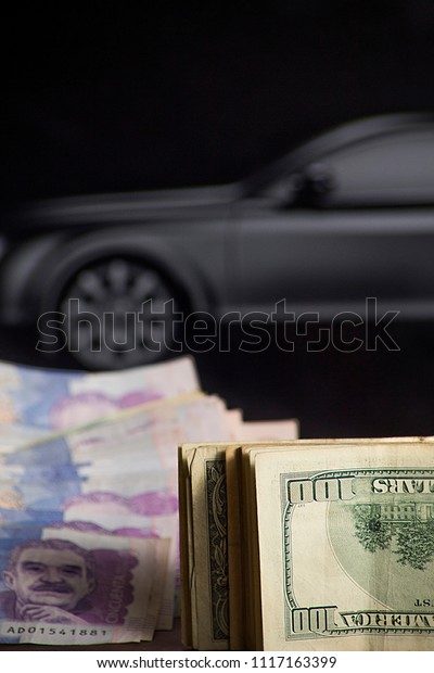 project to buy a car- Colombian dollars and\
money with black car in the\
background