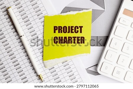 Project charter concept with sticky note, calculator, financial documents and pen representing project planning, scope definition,.
