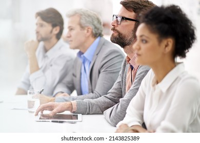 Project Debriefing. Shot Of A Group Of Dedicated Business Professionals Sitting In A Row.