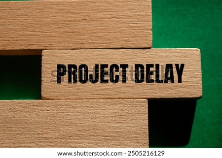 Project delay message written on wooden block with green background. Conceptual project delay symbol. Copy space.