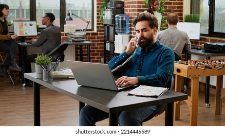 Project Manager Answering Landline Phone Call In Startup Office, Talking To Employee On Phone Line. Using Office Telephone With Cord To Chat And Have Remote Communication At Job.