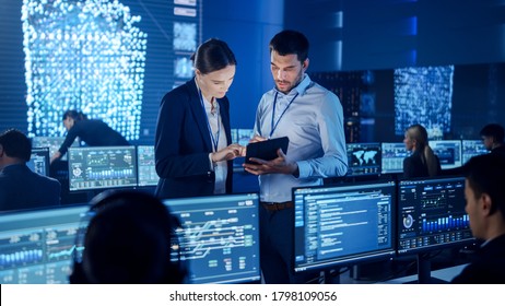 Project Manager and Computer Science Engineer Talking while Using A Digital Tablet Computer. Telecommunications Company System Control and Monitoring Office Room with Working Specialists. - Shutterstock ID 1798109056