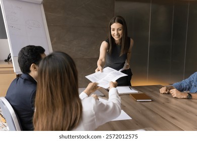 Project manager offering plan, management strategy to diverse team, share financial reports, gives papers, legal document or contract text for learning before signing during group at corporate meeting