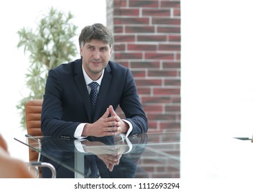 Project manager sitting at a table in an empty conference room