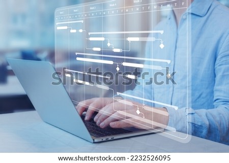 Project manager working with Gantt chart schedule to plan tasks and deliverables. Scheduling activities with a planning software. Work breakdown structure and dependency diagram on computer screen.