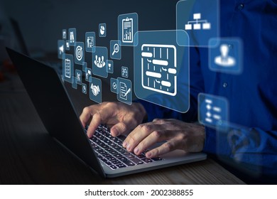 Project manager working on computer at the office. Concept with icons of management areas such as cost, planning, risks, schedule. Person typing on keyboard. - Shutterstock ID 2002388855