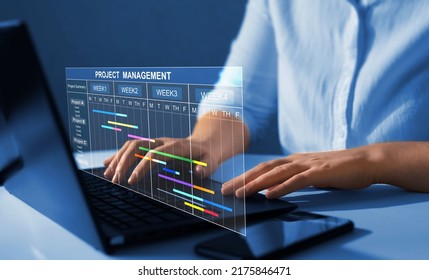 Project manager working on laptop and updating tasks and milestones progress planning with Gantt chart scheduling interface for company on virtual screen.  Business Project Management System.  - Shutterstock ID 2175846471