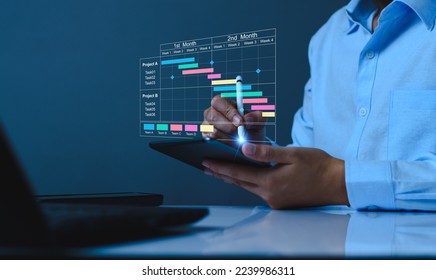 Project manager working on tablet and updating tasks and milestones progress planning with Gantt chart scheduling interface for company on virtual screen. Business Project Management System. - Shutterstock ID 2239986311