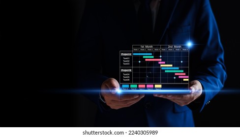Project manager working on tablet and updating tasks and milestones progress planning with Gantt chart scheduling interface for company on virtual screen. Business Project Management System.