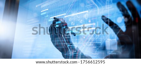Project manager working and update tasks with milestones progress planning and Gantt chart scheduling virtual diagram.Businessman hand pressing an imaginary button on virtual screen