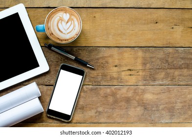 Project workspace with blank screen tablet, blank screen smartphone, coffee cup ,pen and paper.Top view with copy space