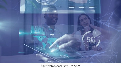 Projecting tablet displaying world map data charts at meeting room, colleagues watching 5G icon. Technology, collaboration, innovation, data, interface, connectivity, futuristic