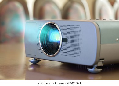 Projector On Office Table Ready For Presentation With Chairs In Background