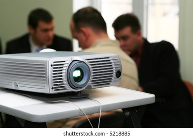 Projector on table with persons behind (horizontal)