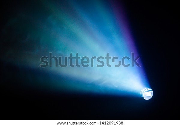 projector spotlight blue color , smoke texture\
background . light beam screening and glowing for movie cinema and\
film multimedia production in dark black room at night . wide lens\
showing, copy space