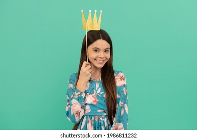 Prom Party. Happy Girl Hold Paper Crown. Prom Queen Blue Background. Contest Winner. Enjoying Photobooth Fun