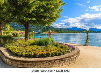 Promenade with flowers along Worthersee lake on beautiful summer day, Austria