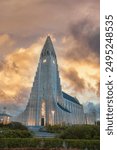 Hallgrímskirkja, a prominent Lutheran church in Reykjavik, Iceland, with a unique design inspired by basalt lava flows, illuminated facade, and vibrant sky.