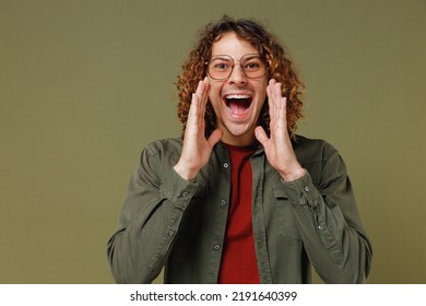 Promoter Vivid Long Curly Hair Young Brunet Man 20s Wears Khaki Shirt Jacket Glasses Scream Hot News About Sales Discount With Hands Near Mouth Isolated On Plain Olive Green Background Studio Portrait