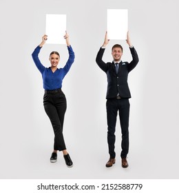 Promotion Billboard. Collage Of Two Business People Holding White Advertisement Board In Hands, Standing Isolated On White Studio Background, Raising Lifting Sign Board Up Above Head, Full Body Length