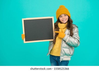 Promotion Concept. Kid Cheerful Promoting. Smiling Girl Wear Winter Outfit Show Blank Chalkboard Copy Space. Informing Kids Community. Kid With Blackboard. Promoting Product. Child Promoting Event.