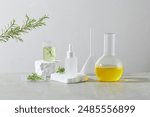 The promotional photo on white background with front view. A boiling flask of yellow liquid next to a funnel, in the middle having an unbranded cosmetic bottle and a beaker placed on white pedestal