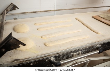 Proofing Loaves Of Bread And Baguettes On Working Surface In Baker Workshop. Traditional Baking Technique