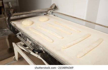 Proofing Loaves Of Bread And Baguettes On Working Surface In Baker Workshop. Traditional Baking Technique