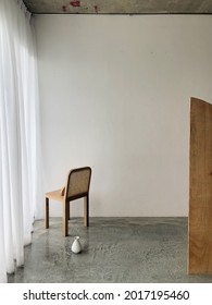 Prop styling at a studio for a photoshoot using a wooden chair, an empty vase, and a wooden partition. 