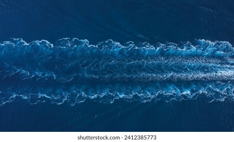 Prop wash of a tanker ship underway open sea. Aerial top down drone view of water foam trace behind a crude oil tanker