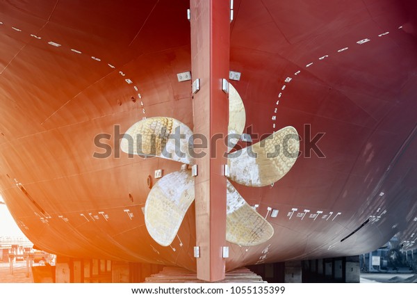propeller closeup of container ship in floating dry dock\
of shipyard 