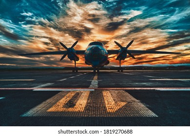Propeller driven aircraft parked at sunset