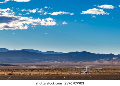 Propeller plane parked at the airport. Small airfield in front of high mountains, sunset over airfield and the light aircraft . - Powered by Shutterstock