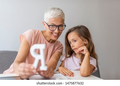 Proper Articulation Therapy For Girl. Stuttering Girl And Speech Therapist. Senior Female Speech Therapist Helping A Young Patient. Repeat After Me.. Session With Alphabet Learning