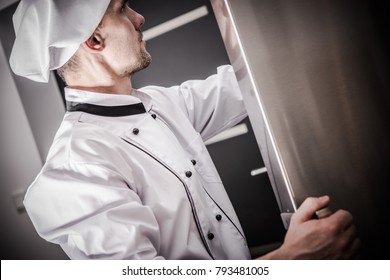 Proper Restaurant Food Storage. Caucasian Chef In His 30s Checking On The Fresh Products In The Commercial Restaurant Refrigerator.