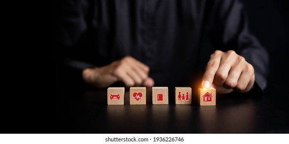 Property (family house) Insurance concept. Businessman with protective gesture and insurance icons: car, travel, family and life, financial and health insurance. - Shutterstock ID 1936226746