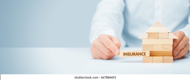 Property (family house) insurance protection concept. Insurance agent complete wooden model of the house with last piece with text insurance. - Shutterstock ID 667884691