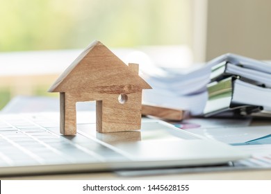 Property Home Model For Loan Real Estate To Buy New For Family Or Mortgage Investment Concept: Wooden House Models On Laptop Computer With Chart Report Documents Contact Customer For Wealth Management