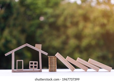 Property insurance and security for housing concept. Coin money prevents wooden blocks from falling into the house model. Use the money to buy insurance to protect against risk.
