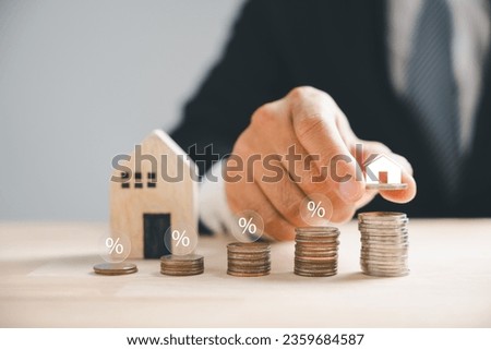 Property investment concept, hand stacks coins with a house. Real estate growth, mortgage finance theme. Smart investment decisions lead to financial success. Property Taxes