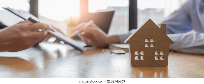 property investment concept. Model home and Client signing a property leasing contract as background. - Shutterstock ID 2132746269